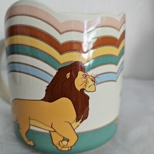 The Lion King ceramic mug. It features characters and a rainbow design inspired
